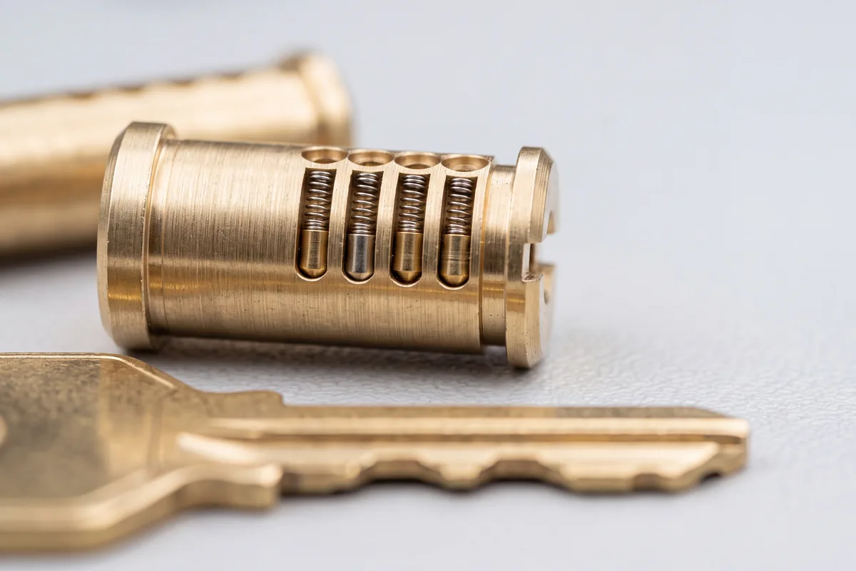 Brass lock cylinder cutaway showing pin tumblers and springs next to a key, Washington DC master key system services